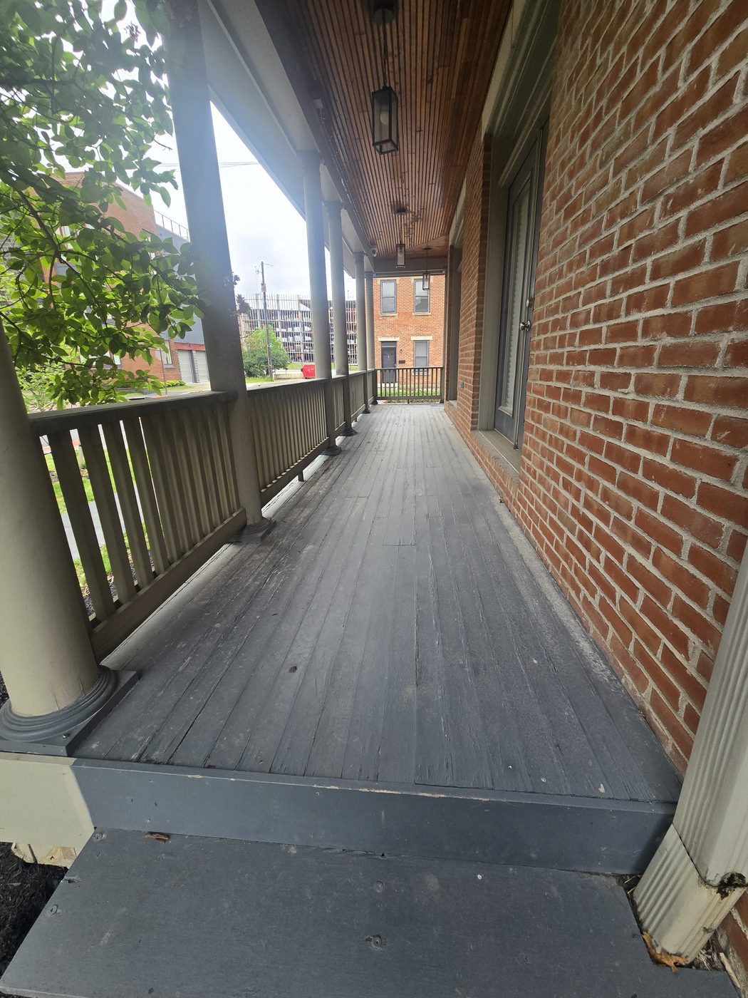 Worn and weathered gray porch floor boards before the rebuild