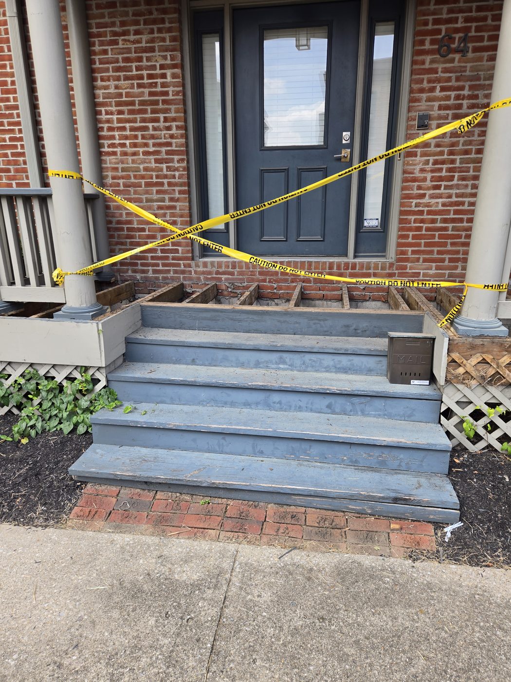 Front steps and porch taped off with caution tape during the rebuild