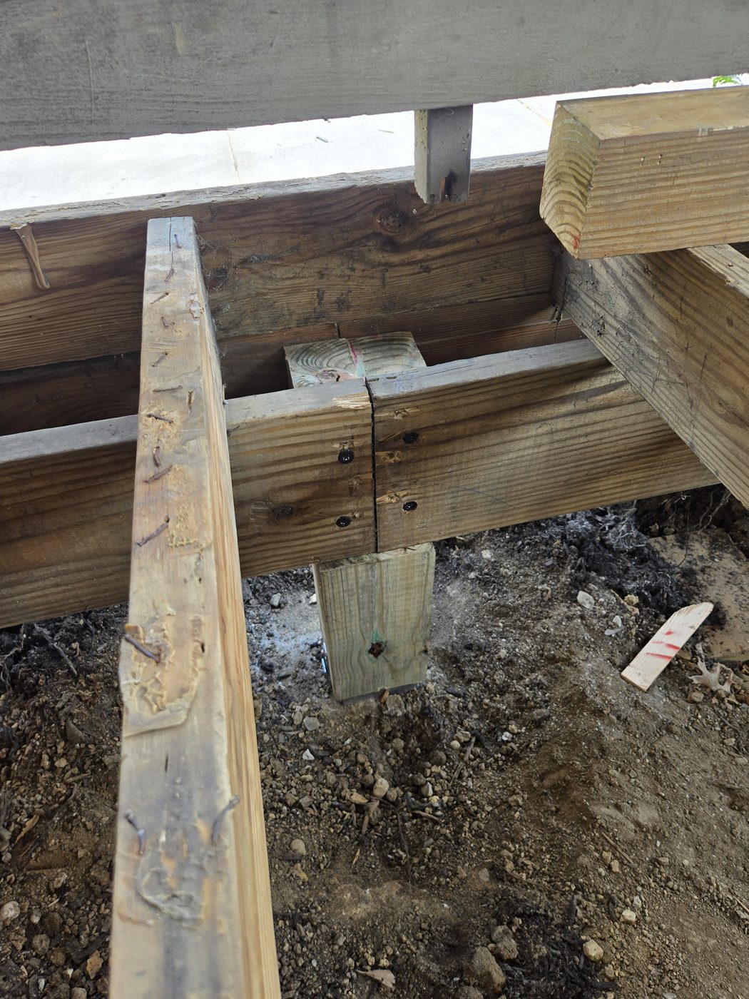 New six by six post on an adjustable metal base supporting a notched porch beam fastened with structural screws